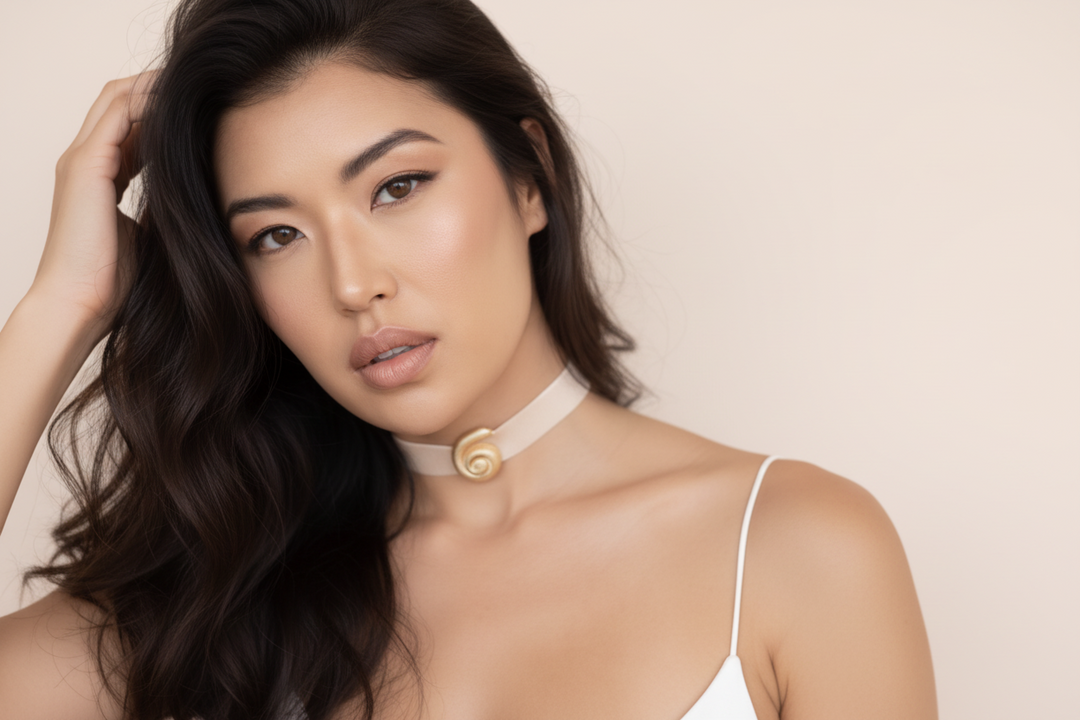 Woman wearing a white top with thin straps against a beige background